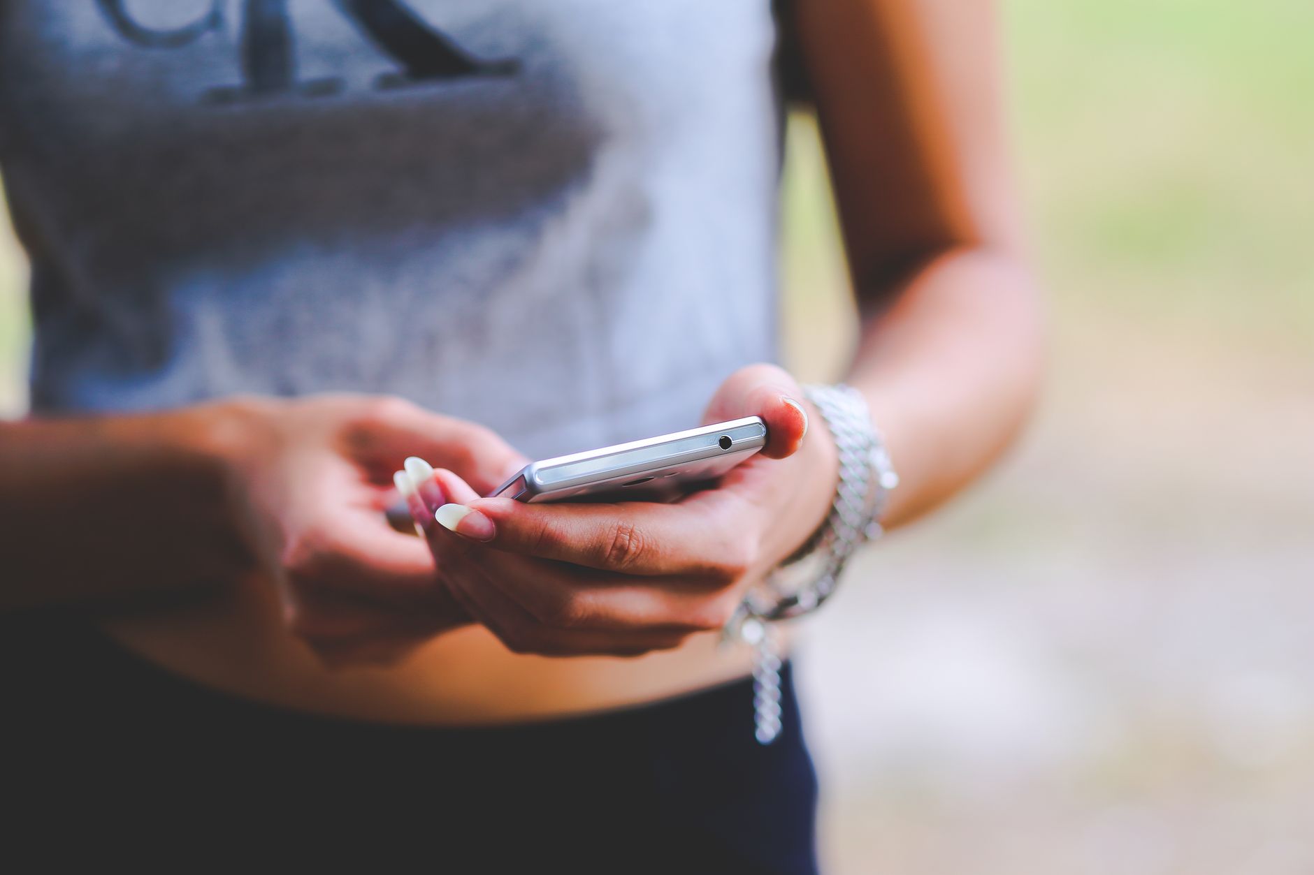 WhatsApp engel süresi - person typing on smartphone messaging app, blurred background, natural light
